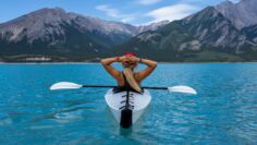 an outdoor sports woman kayaking on a lake in the mountains